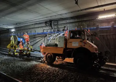 Ein Unimog der Firma Sogetrel steht in einem Bauhaustunnel, daneben sind Bauarbeiter beschäftigt, die Kabel verlegen