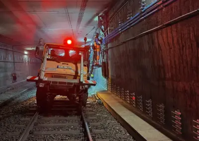 Ein Unimog der Firma Sogetrel steht in einem Bauhaustunnel, daneben sind Bauarbeiter beschäftigt, die Kabel verlegen