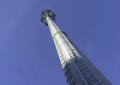 Ein Mobilfunkmast ragt in den blauen Himmel