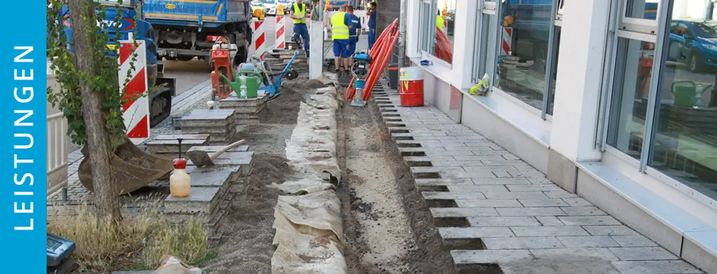 Ein Graben zum Verlegen von Kabeln wurde in einem Gehweg fachmännisch angelegt.