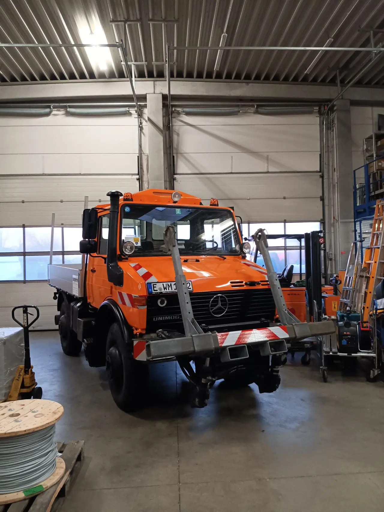 Ein orangefarbener, frisch restaurierter Unimog der Firma Sogetrel